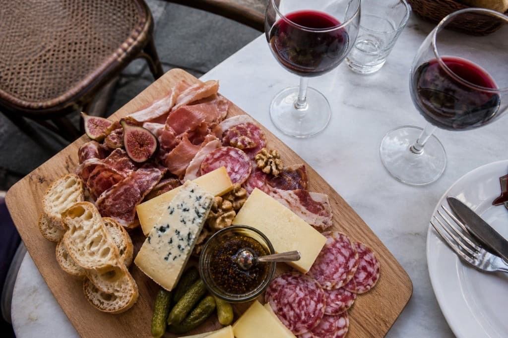 Planche mixte de charcuteries et fromages avec figues et noix sur planche en bois