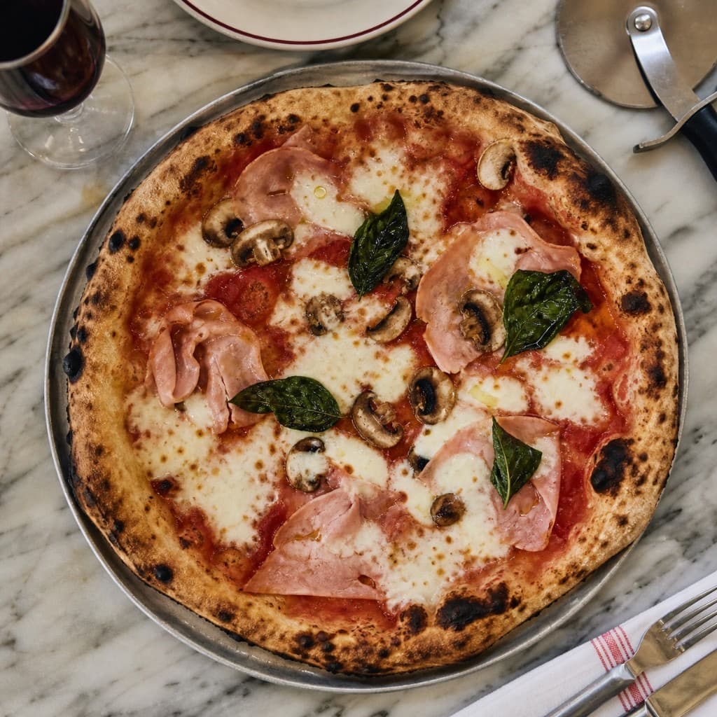 Pizza Regina au four à bois avec jambon, champignons et basilic